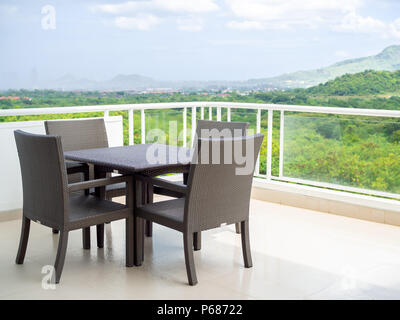 Moderno intreccio di vimini e tavolo da pranzo insieme nella terrazza con vista montagna. Foto Stock