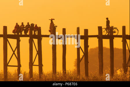Sagome di residenti locali su U Bein bridge al tramonto nei sobborghi di Mandalay, Myanmar Foto Stock