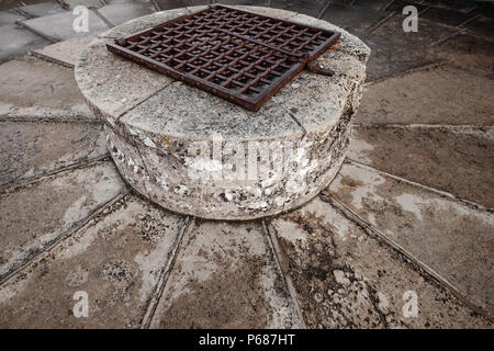 Il pozzo in pietra con arrugginita traliccio metallico montato sulla parte superiore della vecchia torre di castello Foto Stock