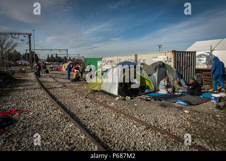 I rifugiati in tende accanto ai binari ferroviari in un campo di fortuna della frontiera Greek-Macedonian vicino al villaggio greco di Idomeni. Foto Stock