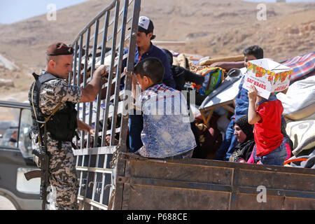 (180628) -- BEIRUT, 28 giugno 2018 (Xinhua) -- rifugiati siriano pack e caricare i loro beni di famiglia con l aiuto di libanesi delle forze di sicurezza nel villaggio di Arsal, Libano, il 28 giugno 2018. Più di 400 rifugiati siriani hanno permesso dalle autorità siriane di tornare a casa loro da Arsal di Qalamoun area nel western Damasco campagna.(Xinhua/Bilal Jawich)(yg) Foto Stock