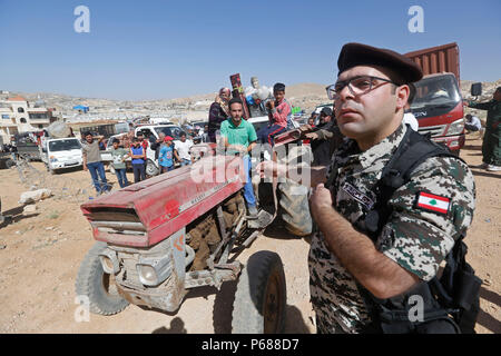 (180628) -- BEIRUT, 28 giugno 2018 (Xinhua) -- rifugiati siriano pack e caricare i loro beni di famiglia con l aiuto di libanesi delle forze di sicurezza nel villaggio di Arsal, Libano, il 28 giugno 2018. Più di 400 rifugiati siriani hanno permesso dalle autorità siriane di tornare a casa loro da Arsal di Qalamoun area nel western Damasco campagna.(Xinhua/Bilal Jawich)(yg) Foto Stock