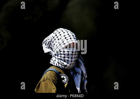 Ramallah, West Bank, Territorio palestinese. Il 29 giugno, 2018. Un mascherato femmina palestinese protester guarda durante gli scontri con le truppe israeliane a seguito di una dimostrazione vicino l'insediamento ebraico di Beit El, vicino a Ramallah in Cisgiordania occupata Giugno 29, 2018 Credit: Shadi Hatem APA/images/ZUMA filo/Alamy Live News Foto Stock