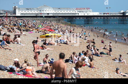 La gente si può prendere il sole sulla spiaggia di Brighton nel Sussex. I britannici sembrano godere le temperature più calde dell'anno per il quarto giorno in una fila di questa settimana con il mercurio prevista per elevarsi a 32C (89.6F). Foto Stock