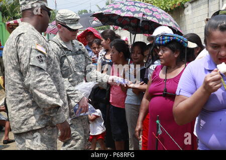 Stati Uniti I soldati Il Mag. James Nelson e Staff Sgt. James Grames dà acqua fuori per giovani e anziani mentre i pazienti in attesa di processo durante una preparazione medica esercizio a San Padro, Guatemala, 17 maggio 2016. Task Force il lupo rosso e l'esercito a sud conduce civile umanitario Assistenza Formazione per includere il livello tattico di progetti di costruzione e preparazione medica Esercizi di formazione fornendo accesso a medici e la costruzione di scuole in Guatemala con il governo del Guatemala e non-agenzie governative dal 05MAR16 a 18GIU16 al fine di migliorare la disponibilità di missione delle forze degli Stati Uniti e per fornire una Foto Stock