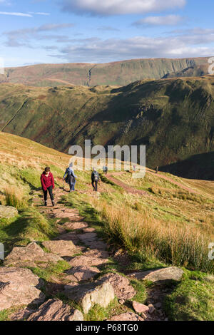 Walkers sul luogo cadde con Beda cadde e castrato oltre la collina nel Parco Nazionale del Distretto dei Laghi, Cumbria, Inghilterra. Foto Stock