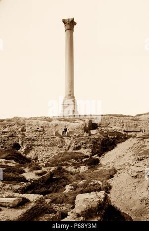 Fotografia della Colonna di Pompeo in Egitto una colonna trionfale in Alessandria, Egitto ed è il più grande del suo genere costruito al di fuori dei capitelli imperiale di Roma. Datata 1905 Foto Stock