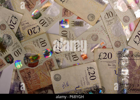 Un gran numero di valuta britannica di venti e dieci pound banconote come immagine di sfondo. Foto Stock