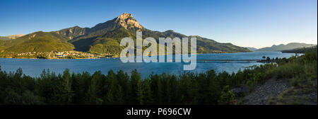 Tramonto sul Grand Morgon picco, Savines-le-Lac villaggio e lago Serre-Poncon (panoramico). Hautes-Alpes, Alpi europee, Francia Foto Stock