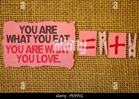La grafia la scrittura di testo si è ciò che si mangia. Voi siete ciò che l'amore.. Concetto significato iniziare a mangiare cibo sano e sacchi di juta più due clip di carta uguale Foto Stock