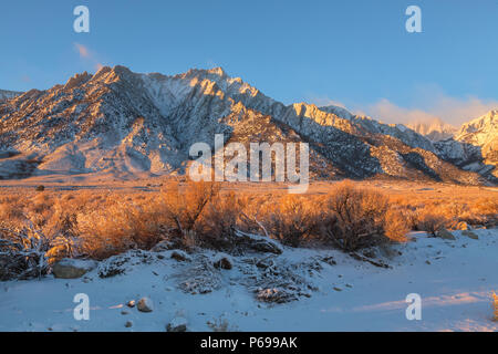 Luce del sole di mattina riflessa sul Lone Pine picco, con Mt. Whitney parzialmente coperta di nebbia, dopo un fine novembre tempesta di neve, Lone Pine, California Foto Stock