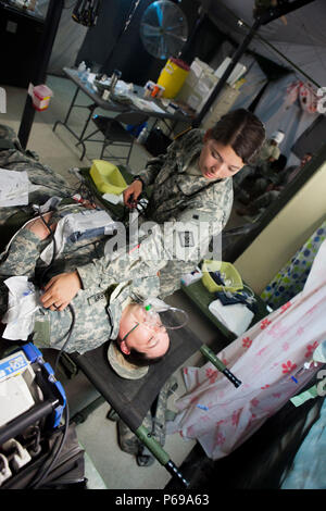 Stati Uniti Army Spc. Tara la campana della 296massa unità di ambulanza, Arkansas Guardia nazionale, tende a paziente Spc. Virginia Armstrong della 875th Forward Support Company, durante una preparazione medica in esercizio la Blanca, Guatemala, 26 maggio 2016. Task Force il lupo rosso e l'esercito a sud conduce civile umanitario Assistenza Formazione per includere tatical livello i progetti di costruzione e preparazione medica Esercizi di formazione fornendo accesso a medici e la costruzione di scuole in Guatemala con il governo Guatamalan e non le agenzie di governo dal 05MAR16 a 18GIU16 al fine di migliorare la disponibilità di missione di noi Foto Stock