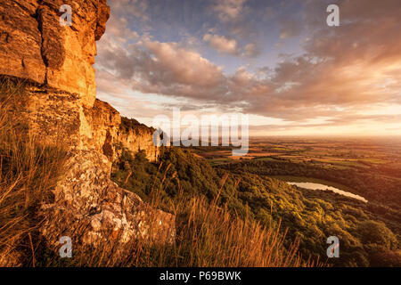 Luce della Sera da Sutton Bank, Englands finest vista. Lago Gormire e la valle di York bagnarsi in golden la luce del sole in distanza. Foto Stock