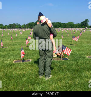 La figlia del Magg. Ben Robbins, 177th Fighter Wing, New Jersey Air National Guard, imposta una bandiera americana su una lapide presso il Generale di Brigata William C. Doyle Memorial Cemetery, Wrightstown, N.J., 28 maggio 2016. Veterani, veterani delle organizzazioni di servizio lungo con New Jersey e la Guardia Nazionale di soldati e aviatori onore ai caduti durante lo stato annuale Giorno Memoriale della cerimonia al cimitero. La cerimonia è culminata con la presentazione del memorial ghirlande dai rappresentanti del veterano organizzazioni di assistenza. Il cimitero, dedicato in 1986, New Jersey suola allo stato azionato per veterani cemeter Foto Stock