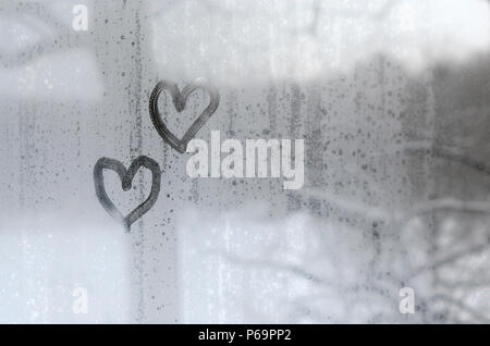 Due cuori dipinta su un vetro colmi d'inverno . Foto Stock