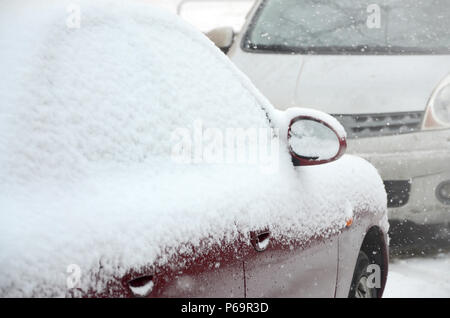 Frammenti di automobili parcheggiate ricoperte di neve . Foto Stock