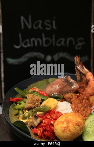 Nasi Jamblang, la firma piatto di riso da Cirebon, West Java. Riso al vapore in foglie di teak parcel servito con abbondanza di piatti laterali. Foto Stock