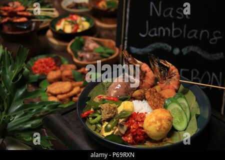 Nasi Jamblang, la firma piatto di riso da Cirebon, West Java. Riso al vapore in foglie di teak parcel servito con abbondanza di piatti laterali. Foto Stock