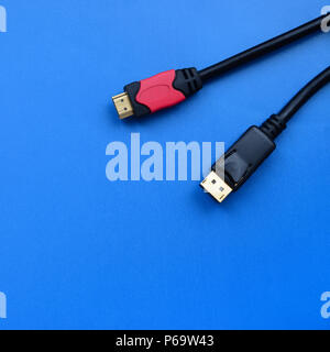 Audio video HDMI computer via cavo e spina a 20 pin DisplayPort maschio connettore placcato oro per un perfetto collegamento su uno sfondo blu . Foto Stock