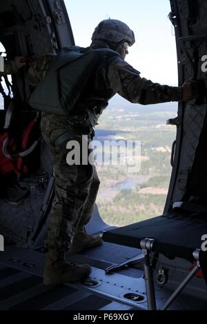 Il personale Sgt. Renaldo Lakharam spinge la testa fuori la porta di un C-27 aerei per garantire condizioni sicure per uscire un paracadutista durante la quarta informazioni militari Support Group Jumpmaster dell'anno di competizione, 8 aprile 2016. Lakharam, assegnato alla sede centrale e sede di Co, 4 MISG, e altri due jumpmasters sono stati testati sulla loro idoneità fisica e competenza nella conduzione di jumpmaster dazi in aria e a terra, e il generale jumpmaster conoscenze durante il multi-giorni di gara. Lakharam è stato annunciato il vincitore durante una cerimonia di premiazione il 20 maggio 2016. Foto Stock