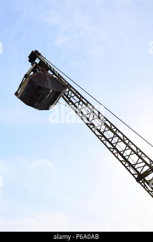 Vecchio giallo benna meccanico afferra il cielo azzurro sfondo . Foto Stock