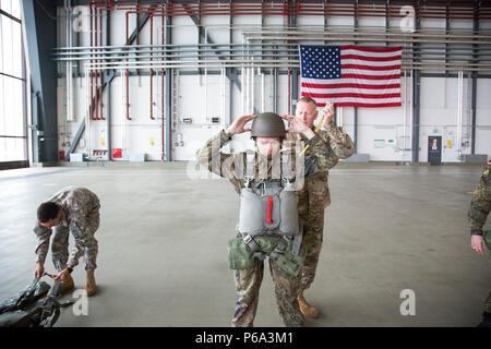 Stati Uniti Esercito il Mag. Cristopher D. Murphy, 982nd combattere la società della fotocamera (airborne), East Point, Ga., commander, aiuta un paracadutista tedesco a prepararsi per un US/Deutschland amicizia Jump, Ramstein Air Force Base, 25 maggio 2016. Lo scopo dell'amicizia jump è di promuovere e alimentare degli Stati Uniti e le relazioni tedesche, sviluppare l'interoperabilità durante il corso di formazione e di fornire una base per le future operazioni in formazione e in ambienti reali. (U.S. Esercito foto di Spc. Tracy McKithern/rilasciato) Foto Stock