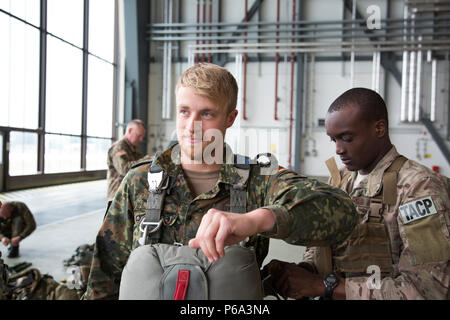 Stati Uniti e paracadutisti tedeschi a prepararsi per le operazioni di volo durante un US/Deutschland amicizia Jump, Ramstein Air Force Base, 25 maggio 2016. Lo scopo dell'amicizia jump è di promuovere e alimentare degli Stati Uniti e le relazioni tedesche, sviluppare l'interoperabilità durante il corso di formazione e di fornire una base per le future operazioni in formazione e in ambienti reali. (U.S. Esercito foto di Spc. Tracy McKithern/rilasciato) Foto Stock