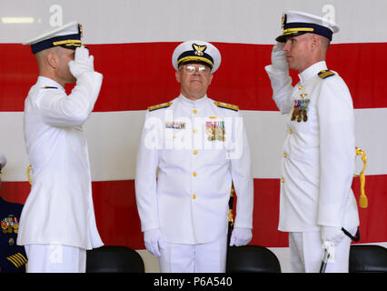 Il cap. Daniel Travers restituisce un saluto a Capt. William Timmons, mentre viene sollevato dal comando durante una cerimonia celebrata da Adm posteriore. Richard Gromlich, Comandante della Guardia Costiera XIII quartiere, in corrispondenza del settore di base in Warrenton, Ore., 27 maggio, 2016. Timmons è proveniente dall area del Pacifico Il comando situato in Alameda, California, dove era stato il capo delle operazioni future filiale. Stati Uniti Coast Guard foto di Sottufficiali di prima classe Levi leggere. Foto Stock