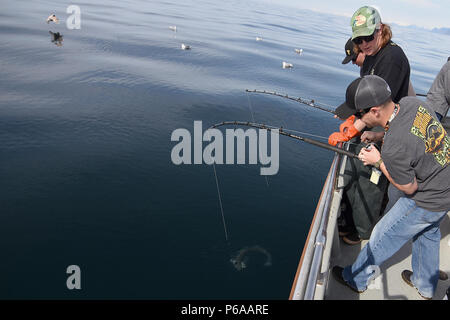 Ponte di volontariato mano Kyle Collins parla di un pescatore militare attraverso lo sbarco di una spinosa palombo nel decimo annuale servizi armati contro Torneo di pesca 26 Maggio a bordo della Seward militare barca Resort, Snowbird. Il torneo, ospitato dalla città di Seward e le Forze Armate YMCA, ha dato più di 200 pescatori militari di stanza in Alaska gratuitamente una giornata di pesca halibut per ringraziarli per il loro servizio. (Esercito foto/John Pennell) Foto Stock