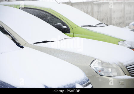 Frammenti di automobili parcheggiate ricoperte di neve . Foto Stock