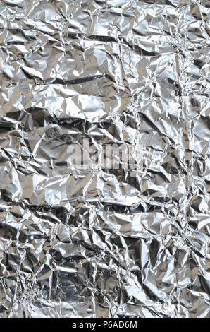 Sottile foglio stropicciato di frantumato di stagno argento alluminio foil sfondo con lucida superficie accartocciata per texture . Foto Stock