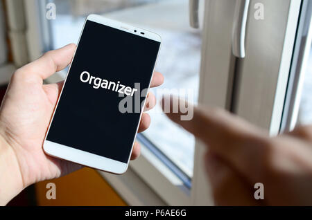 Una persona vede un iscrizione in bianco su nero display dello smartphone che tiene in mano. Agenda elettronica . Foto Stock