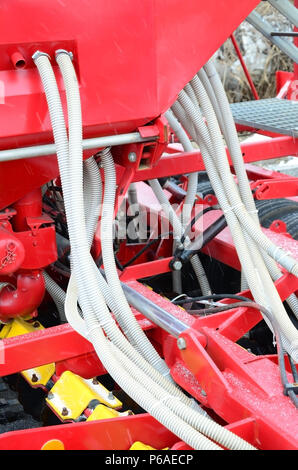 Molle e tubi sono disposti in una fila. Una fila di una seminatrice. Attrezzature pesanti sulla fiera agricola . Foto Stock