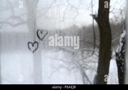 Due cuori dipinta su un vetro colmi d'inverno . Foto Stock