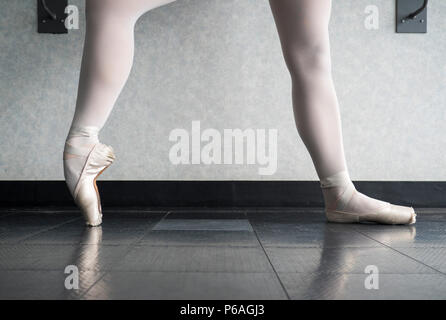 Ballerina in classe di balletto in fase di riscaldamento ha pointe shoes, balletto pantofole a barre Foto Stock