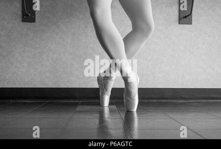 Versione in bianco e nero della Ballerina Ballerina nel balletto studio en pointe releve in quarta posizione Foto Stock