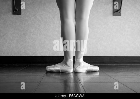 Versione in bianco e nero di vista posteriore della ballerina ballerina a barre nel corso di danza in piedi in prima posizione Foto Stock