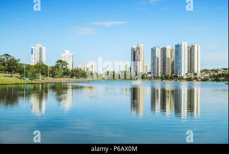 Lago di un parco urbano in una bella giornata di sole. L'acqua del lago con alcuni edifici sullo sfondo e la natura intorno a. Foto a Campo Grande MS Foto Stock