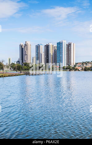 Lago di un parco urbano con un ponte su una bella giornata di sole. L'acqua del lago con alcuni edifici sullo sfondo e qualche natura intorno. Una foto Foto Stock