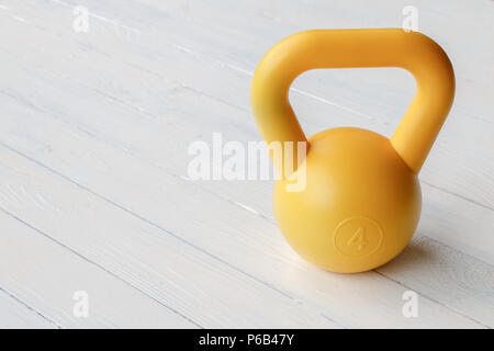 Cerchio giallo dumbbell bianco sul tavolo di legno utilizzate per la cura della salute Foto Stock