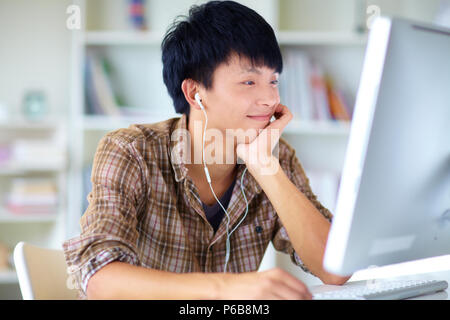Giovane uomo asiatico l uso dei computer in ufficio in casa Foto Stock