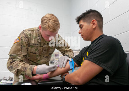 La Georgia Esercito Nazionale Guardsman PFC. Charles Baker del 3° Battaglione, 121 Reggimento di Fanteria aspira il sangue dal PFC. Luis Rodriguez della 138th Chemical company durante il mese di giugno 24, 2018 soldato elaborazione di fattibilità presso il Camp di argilla, Marietta in Georgia. Foto Stock