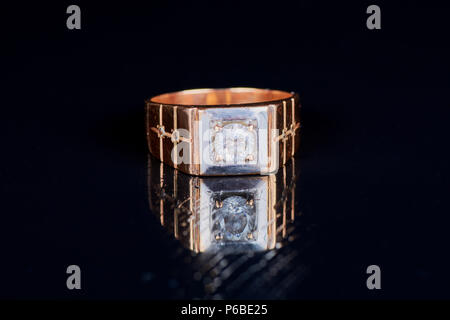 Oro uomini anello su uno sfondo nero Foto Stock