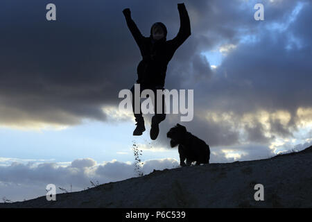 Wustrow, Germania - silhouette, ragazzo fa un salto in aria Foto Stock