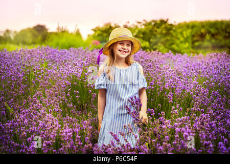 Femmina di bambini che giocano nel campo di lavanda sotto la pioggia di estate Foto Stock