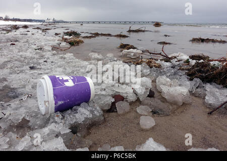 Ahlbeck, Germania, Vuoto tazza da caffè sdraiato sulla spiaggia nel ghiaccio Foto Stock