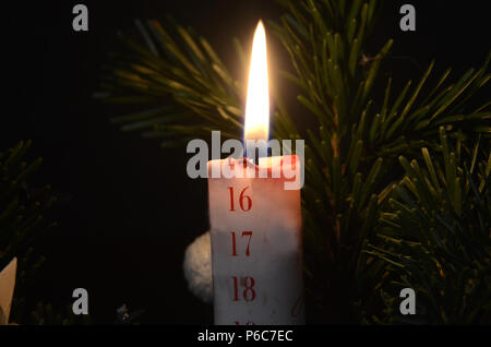 Natale calendario candela ha bruciato fino al 16 dicembre. Foto Stock