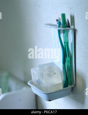 Close-up di spazzolini da denti e sapone nel vecchio rack di smalto Foto Stock