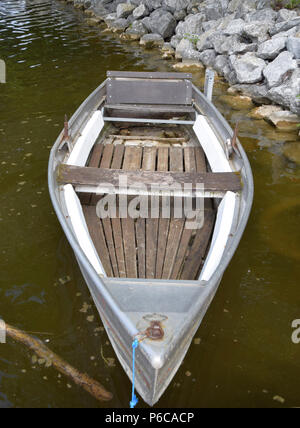 Trascurato il vecchio e marcio riga barca realizzata in metallo e legno vecchio legno e metallo per le barche a remi attaccato con un blu corda sintetica Foto Stock