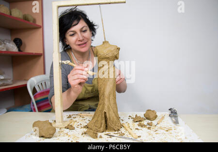 Artista scultore creando un busto scultura con argilla Foto Stock